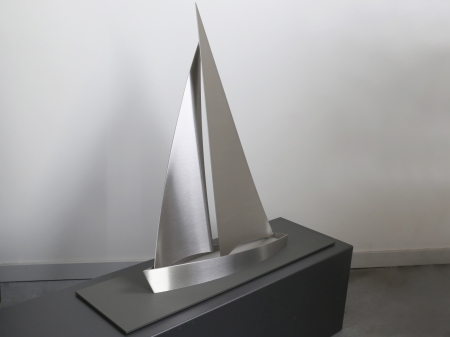 A threedimensional display of a stainless steel sailing boat, placed on metallic powder coated base plate. Measurements: Object 15 x 65 x 60 cm, Series of 8 pieces. Still available. Request information how much is still available and where exhibited.