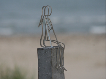 Stainless steel thread figure of a woman sitting on a bluestone pedestal. Measurements: Figure 32 x 15 x 10 cm. Pedestal 130 x 12 x 8 cm. Series of 8, of which 3 sold.